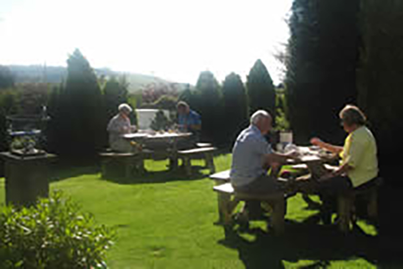 Guests relaxing in the garden at Raddicombe Lodge